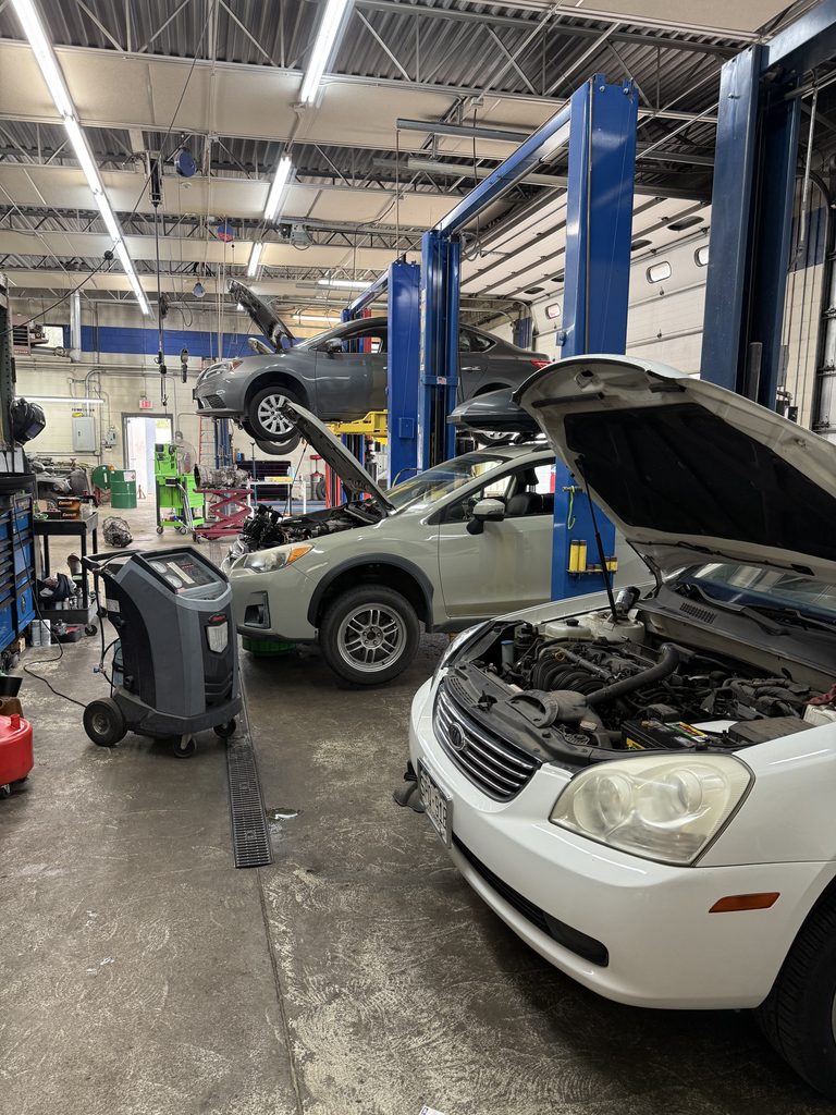 Vehicles being serviced inside Campus Auto Repair in Fort Collins, Colorado