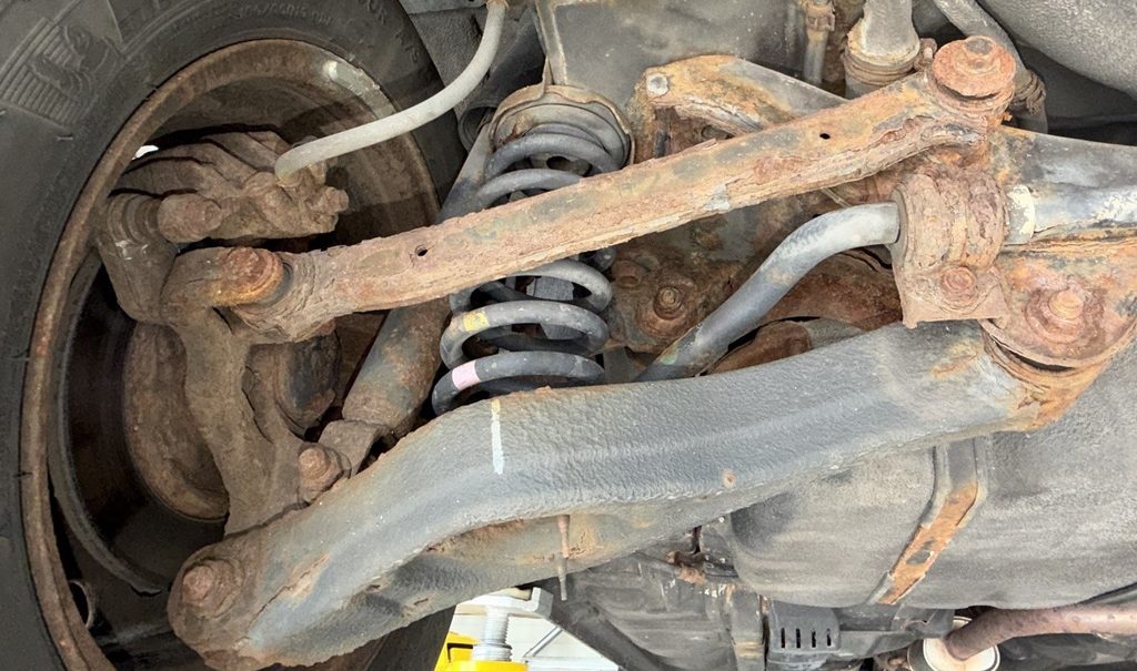 Rusted suspension control arm inspected at Campus Auto Repair in Fort Collins